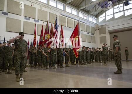 Marines with 4th Marine Logistics Group salute and present colors during a Change of Command ceremony at the Combat Logistics Regiment 4 headquarters in Kansas City, Mo., July 14, 2018. Change of Command ceremonies mark the passage of command from one Marine to another, symbolizing the transfer of responsibilities of his or her command position. And, as such, authorities and responsibilities of 4th MLG were formally passed from Maj. Gen. Helen Pratt to Brig. Gen. Karl Pierson. Stock Photo