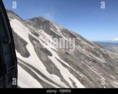 A Coast Guard aircrew aboard an MH-60 Jayhawk helicopter from Coast Guard Air Station Astoria flies over Mount St. Helens, Washington, July 14, 2018, where they medically evacuated an injured hiker. The hiker was airlifted to Oregon Health Science University Hospital in Portland where she was treated for lacerations and a possible broken hip. U.S. Coast Guard Stock Photo