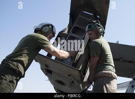 Jordan (July 8, 2018) U.S. Marine Sgt. Wesley Huntress and U.S. Marine Cpl. Tyler Worley, assigned to the 26th Marine Expeditionary Unit, put an MV-22 Osprey helicopter exhaust system back together the flight deck aboard the Wasp-class amphibious assault ship USS Iwo Jima (LHD 7), July 8, 2018 during the ship’s mid-deployment voyage repair. Iwo Jima is deployed to the U.S. 5th Fleet area of operations in support of naval operations to ensure maritime stability and security in the central region, connecting the Mediterranean and the Pacific through the western Indian Ocean and three strategic c Stock Photo