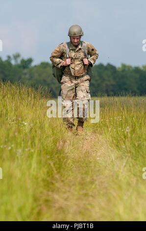 Army 1st Lt. Josiah Poisal, Executive Officer of the Georgia Army National Guard 165th Quartermaster Company, from Gen. Lucius D. Clay National Guard Center, Marietta, Georgia, walks off the drop zone after a successful jump at the Preston Drop Zone on Fort Gordon, Georgia, July 14, 2018. Stock Photo