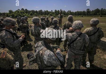 U.S. Army National Guard Soldiers from Bravo Company, 1st Battalion, 114th Infantry (Air Assault) listen to a safety briefing before being picked up by UH-60L Black Hawk helicopters at Contingency Operation Location Victory on Joint Base McGuire-Dix-Lakehurst, N.J., July 16, 2018. Stock Photo