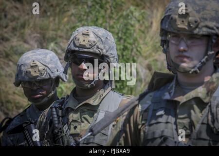 U.S. Army National Guard Soldiers from Bravo Company, 1st Battalion, 114th Infantry (Air Assault) listen to a safety briefing before being picked up by UH-60L Black Hawk helicopters at Contingency Operation Location Victory on Joint Base McGuire-Dix-Lakehurst, N.J., July 16, 2018. Stock Photo