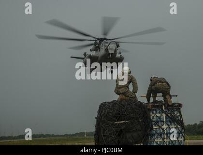 U.S. Marines with Special Purpose Marine Air-Ground Task Force  Southern Command observe as a CH-53E Super Stallion helicopter approaches during an external lift exercise in Flores, Guatemala, July 18, 2018. The Marines and sailors of SPMAGTF-SC are conducting security cooperation training and engineering projects alongside partner nation military forces in Central and South America. The unit is also on standby to provide humanitarian assistance and disaster relief in the event of a hurricane or other emergency in the region. Stock Photo