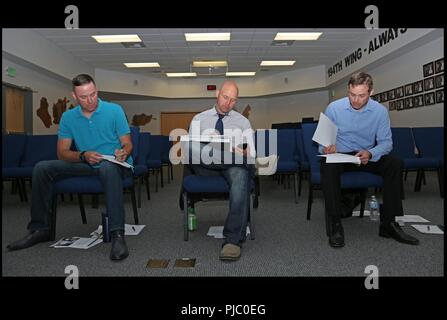 From left, Master Sgt. Jason Usher, operations manager for the 248 Civil Engineer flight, Chief Master Sgt. Jason Witts, Force Support Squadron superintendent, and Maj. Jason Kramer director of plans and programs for the 194th wing, all assigned to the Washington Air National Guard 194th Wing, look at notes in between idea pitches for the innovation initiative July 13th 2018, in Camp Murray, Wash. The Innovation Initiative is a project to use Airmen based ideas to utilize $100k from the National Guard Bureau to enhance Airmen experience and their impact. Stock Photo