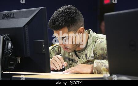 Spc. Nicholas Sobel from the U.S. Army Center for Initial Military Training, takes the written exam portion of the TRADOC Best Warrior Competition, Fort Gordon, Georgia, July 19, 2018. The Best Warrior Competition recognizes TRADOC NCOs and Soldiers who demonstrate commitment to the Army Values, embody the Warrior Ethos, and represent the force of the future by testing them with physical fitness assessments, written exams, urban warfare simulations, and other warrior tasks and battle drills. Stock Photo