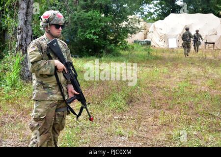 In this image, released by the U.S. Army Reserve, Soldiers with the 420th Engineer Brigade conduct security operations during River Assault 2018 at Fort Chaffee, Arkansas, July 18, 2018. The exercise stresses the warrior and engineer skills of the troops as they engage two weeks of training in weapons familiarity, security, and wet gap crossing in a tactical environment. Stock Photo