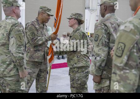 Incoming 335th Signal Command (Theater) (Provisional) commander U.S. Army  Brig. Gen. Nikki L. Griffin Olive receives the guidon from U.S. Army  Lt. Gen. Michael X. Garrett, U.S. Army Central (USARCENT) commanding general during the 335th Signal Command (T)(P) change of command ceremony at Camp Arifjan, Kuwait, July 19, 2018. Transitions between units are a vital component of maintaining an enduring USARCENT posture in the region. Stock Photo