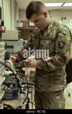Spc. Steven Bauer, a 94E, radio communications security (COMSEC) repairer from Indianapolis, Indiana validates and test radio equipment. Being able to communicate is critical on the battlefield. Whether speaking to ground force units or air traffic controllers, Bauer does his part to help TF Destiny aviators communicate. Stock Photo