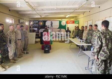 HELMAND PROVINCE, Afghanistan (July 14, 2018) - U.S. Marine Corps advisors with Task Force Southwest stand at attention while Afghan National Army 215th Corps soldiers play the Afghan national anthem during a non-commissioned officer (NCO) leadership course opening ceremony at Camp Shorabak. The ANA NCOs will participate in a three-week-long leadership course designed to develop small-unit leadership skills. Stock Photo