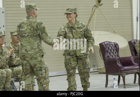 Incoming 335th Signal Command (Theater) (Provisional) commander U.S. Army Brig. Gen. Nikki L. Griffin Olive shakes hands with outgoing 335th SC (T) (P) commander Brig. Gen. John H. Phillips after he delivered his outgoing remarks at the 335th SC (T) (P) change of command ceremony at Camp Arifjan, Kuwait, July 19, 2018. Modern and relevant framework for readiness supports the efforts of allied and coalition land forces throughout the area of responsibility. Stock Photo