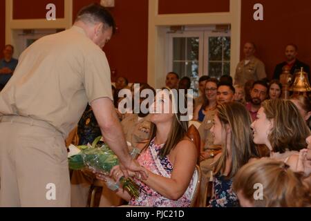 Master Chief James Baker presents flowers to his wife during his retirement ceremony at Marston Pavilion aboard Marine Corps Base Camp Lejeune July 13, 2018. Baker served 30 years in the United States Navy. His career included nearly two decades serving as a Special Amphibious Reconnaissance Corpsman. Baker's more recent role was Command Master Chief at Naval Medical Center Camp Lejeune. Stock Photo