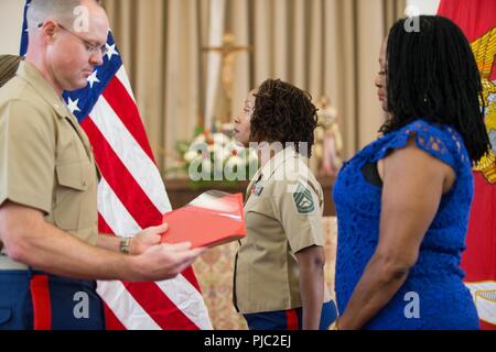 A U.S. Marine retires Gunnery Sgt. Tremakia N. Summerlin, right, procurement chief, Marine Corps Installations Command National Capital Region, at the Marine Corps Base Quantico Memorial Chapel, Quantico, Va., July 6, 2018. Summerlin retired after 20 years of faithful service in the United States Marine Corps. Stock Photo