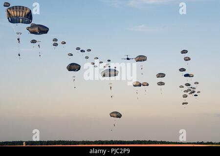 U.S. Army Paratroopers assigned to 1st Brigade Combat Team, 82nd Airborne Division, descend on Holland Drop Zone during Operation Devil Storm on Fort Bragg, N.C., July 19, 2018. Operation Devil Storm was a training event that exercised the unit’s ability to jump, fight and win within 18 hours of notification. Stock Photo