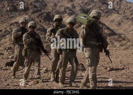 CAMP TITIN, Jordan (July 8, 2018) U.S. Marines assigned to Combat Logistics Battalion-26 (CLB-26), 26th Marine Expeditionary Unit (MEU), move into position for breaching during sustainment training at Camp Titin, Jordan, July 8, 2018. Iwo Jima is the flagship for the Iwo Jima Amphibious Ready Group and, with the embarked 26th Marine Expeditionary Unit, is deployed to the U.S. 5th Fleet area of operations in support of naval operations to ensure maritime stability and security in the Central region, connecting the Mediterranean and the Pacific through the western Indian Ocean and three strategi Stock Photo