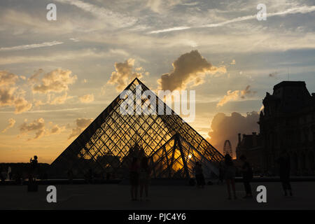 Louvre Pyramid (Pyramide du Louvre) designed by Chinese-American architect I.M. Pei (1989) in front of the Louvre Palace (Palais du Louvre) in Paris, France, at sunset. Stock Photo