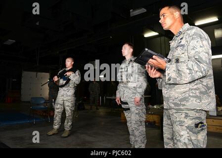 From Left, U.S. Air Force Staff Sgt. Justin D. Goerss, Senior Airman Damien J. Boyd, security forces members with the 174th Attack Wing, New York Air National Guard and Peter J. Terry, commander of the 174th Security Forces Squadron, conduct training on the PRIsm (Professional Range Instruction Simulator) during the PATRIOT North 18 at Volk Field, Wis. on July 15, 2018. PATRIOT is a Domestic Operations disaster-response training exercise conducted by National Guard units working with federal, state and local emergency management agencies and first responders. Stock Photo
