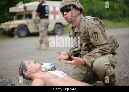 U.S. Army Spc. Frederick Winters from Charlie Company, 725th Brigade Support Battalion (Airborne), 4th Infantry Brigade Combat Team (Airborne), 25th Infantry Division checks for bleeding on a dummy patient during a company level “best medic” competition July 24, 2018 at Joint Base Elmendorf-Richardson, Alaska. The 725th Brigade Support Battalion is conducting a 4 day challenge to select two medics to be sent as competitors to the USARAK best medic competition. Stock Photo