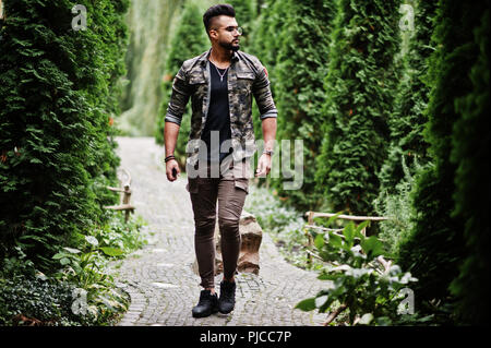 Awesome beautiful tall ararbian beard macho man in glasses and military jacket posed outdoor. Stock Photo