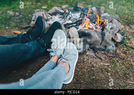 leg of two persons in front of camp fire. hiking Stock Photo