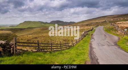 A single track country lane runs through the limestone karst landscape of England's Yorkshire Dales National Park. Stock Photo