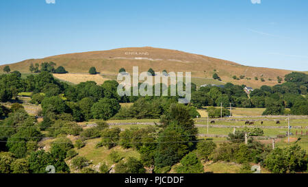 Buxton, England, UK - July 2, 2018: Chelmorton Low hill in the Derbyshire Peak District is decorated with a giant 'England' sign and flag during the 2 Stock Photo