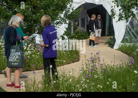 People about to enter Living Laboratory being greeted & given leaflet by volunteer at entrance - RHS Chatsworth Flower Show, Derbyshire, England, UK Stock Photo