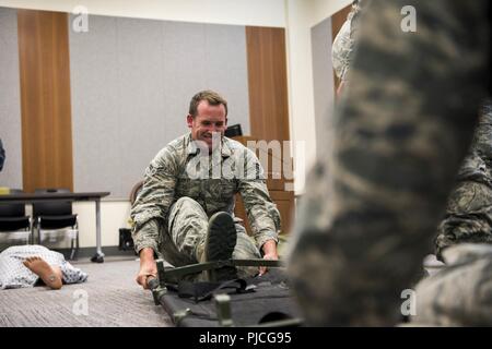 U.S. Air Force Airman 1st Class Dakoda Wholly, an aerospace medical technician assigned to the 673d Medical Operation Squadron, opens a litter during a Tactical Combat Casualty Care course at Joint Base Elmendorf-Richardson, Alaska, July 12, 2018. The course is designed to provide efficient care during combat by teaching life-saving techniques. Stock Photo