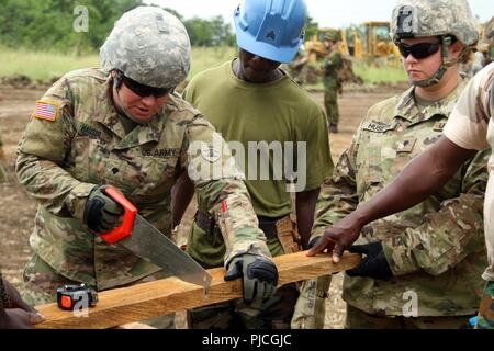 Soldiers with the North Dakota National Guard team up with the Ghana Armed Forces to assemble structures at the Bundase Training Camp, Ghana, during United Accord 2018 at the  July 20, 2018. UA18 is a Ghana Armed Forces & U.S. Army Africa hosted exercise consisting of four combined, joint components: a computer-programmed exercise (CPX), field training exercise (FTX), Jungle Warfare School (JWS) and medical readiness training exercise (MEDRETE). West-African partner militaries, NATO Allies and U.S. Army Africa will execute each component in Accra, Ghana and surrounding areas. Stock Photo