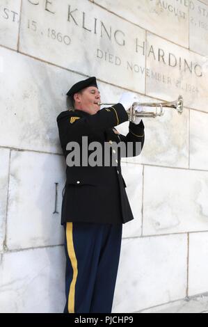Staff Sgt. Dave Lambermont, bugler, 338th Army Band, 88th Readiness Division, plays taps during the ceremony honoring the service and legacy of Warren G. Harding, the 29th president of the United States, in Marion, Ohio July 21. Stock Photo