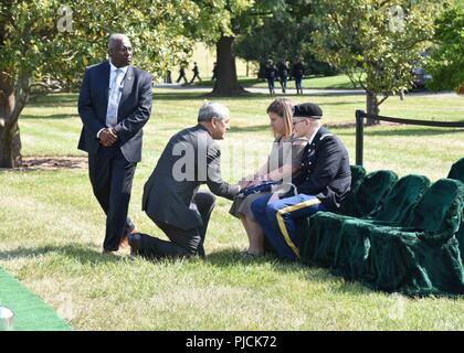 Kelly McKeague, kneeling, Defense POW/MIA Accounting Agency director, speaks with Tonya McClain, grand-niece of Army Pfc. Walter W. Green, during Green's funeral at Arlington National Cemetery, Virginia, July 20. In November 1950, Green was a member of Company E, 2nd Battalion, 8th Cavalry Regiment, 1st Cavalry Division, participating in combat actions against the Chinese People’s Volunteer Forces (CPVF) in the vicinity of Unsan, North Korea. Green, 18, of Zanesville, Ohio, was reported missing in action as of Nov. 2, 1950 when he could not be accounted for by his unit. He was recently identif