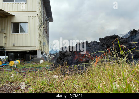lava from Kilauea Volcano, and emanating from a fissure in Leilani Estates, near Pahoa, Puna, Hawaii (the Big Island), approaches a house, Hawaii, USA Stock Photo