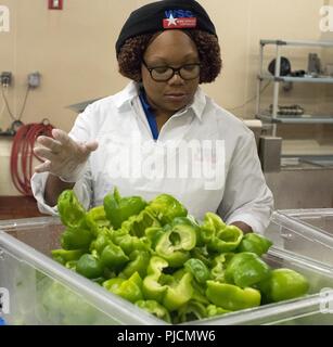 Food processing specialist Monika Williams cleans and removes seeds from green bell peppers at the Central Preparation Kitchen at Sheppard Air Force Base, July 17, 2018. Williams and other Work Services Corp. employees play a valuable role in food preparation to help provide more than 10,000 meals daily for Airmen, Soldiers, Sailors, Marines and international students attending courses at Sheppard. Stock Photo