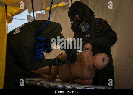 Decontamination Marines with Decontamination Platoon, Chemical Biological Incident Response Force decontaminate a simulated casualty during Exercise Chicago Response in Champaign, Illinois, July 24, 2018. This was the first time the active duty response force trained with Chicago-area first responders and served to establish a working relationship between CBIRF and the cities of Champaign and Chicago. Stock Photo