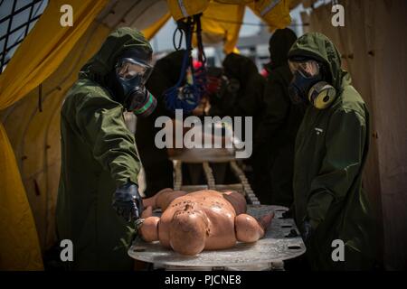 Decontamination Marines with Decontamination Platoon, Chemical Biological Incident Response Force decontaminate a simulated casualty during Exercise Chicago Response in Champaign, Illinois, July 24, 2018. This was the first time the active duty response force trained with Chicago-area first responders and served to establish a working relationship between CBIRF and the cities of Champaign and Chicago. Stock Photo