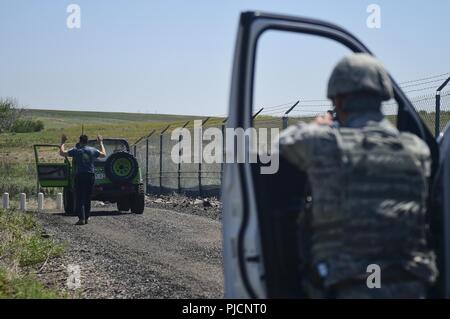 Senior Airman Alexander Warren, 460th Security Forces Squadron patrolman, keeps watch during detainment measures of a suspected “terrorist” during Exercise Panther View 18-3 July 24, 2018, on Buckley Air Force Base, Colorado. Role players are used to help prepare Team Buckley members for real world scenarios. Stock Photo