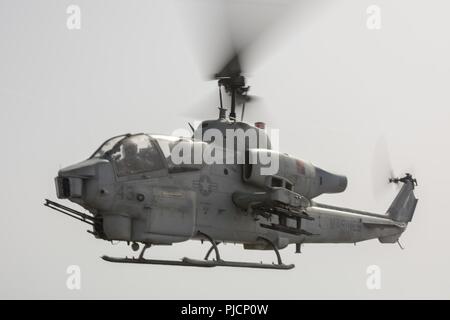 MEDITERRANEAN SEA (July 18, 2018) An AH-1W Cobra helicopter, attached to Marine Medium Tiltrotor Squadron (VMM) 162 (Reinforced), takes off from the flight deck of the San Antonio-class amphibious transport dock ship USS New York (LPD 21) July 18, 2018. New York, homeported in Mayport, Florida, is conducting naval operations in the U.S. 6th Fleet area of operations in support of U.S. national security interests in Europe and Africa. Stock Photo