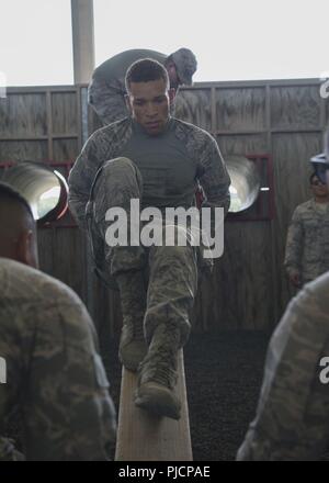 Airman 1st Class Craig Smith, a 71st Security Forces Squadron Airman, slides down a wood plank while navigating an obstacle July 24, 2018, at Joint Base San Antonio – Camp Bullis, Texas to prepare for the 2018 Defender Challenge. The competition will pit security forces teams against each other in realistic weapons, dismounted operations and relay challenge events. Stock Photo