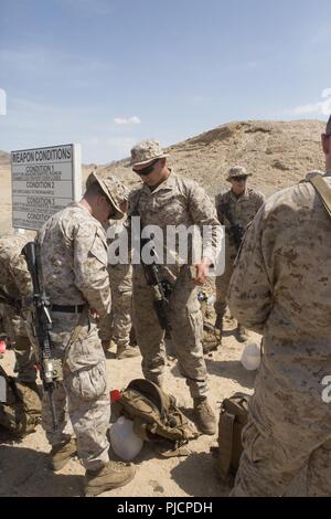 U.S. Marines and Sailors with 3rd Battalion, 6th Marine Regiment are inspected for live ammunition following a battle sight zero range on Marine Corps Air Ground Combat Center Twentynine Palms, CA, on July 13, 2018. The purpose of this inspection is to ensure that all live ammunition is accounted for. Stock Photo