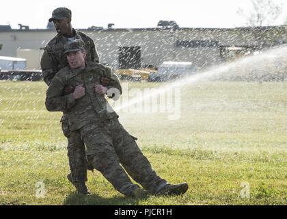 Airmen with the 91st Security Forces Group complete a buddy-drag during the Tactical Response Force tryouts at Minot Air Force Base, North Dakota, July 18, 2018. TRF is a special weapons and tactics team tasked with protecting Minot Air Force Base’s nuclear assets. Stock Photo