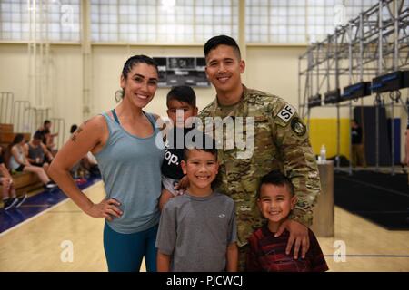 Master Sgt. Christofer Galbadores, 821st Contingency Response Squadron force protection flight chief, stands with his wife, Yasmin, and their three sons, Cain, Maximus and Kingston July 23 at Travis Air Force Base, Calif. The Galbadores couple both ran on the Alpha Warrior 'big rig' while their sons watched them from the crowd. Stock Photo