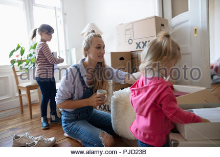Mother and daughters packing moving boxes