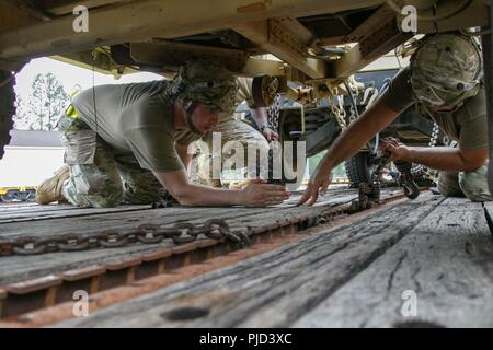 U.S. Army paratroopers assigned to 1st Battalion, 319th Field Artillery Regiment, 3rd Brigade Combat Team, 82nd Airborn Division, secure tactical vehicles onto selected railcars at the Fort Bragg railyard during the 1st Brigade Combat Team, 82nd Airborne Division’s Deployment Readiness Exercise on July 18, 2018. The DRE is designed to test the overall effectiveness and readiness of selected units when called upon to deploy within an 18-hour period. Stock Photo