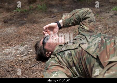 Sgt. John Gilleland from Maneuver Center of Ecellence tries to catch his breath after the first phase of the mystery event during the TRADOC Best Warrior Competition, Fort Gordon, Georgia, July 18, 2018. The Best Warrior Competition recognizes TRADOC NCOs and Soldiers who demonstrate commitment to the Army Values, embody the Warrior Ethos, and represent the force of the future by testing them with physical fitness assessments, written exams, urban warfare simulations, and other warrior tasks and battle drills. Stock Photo