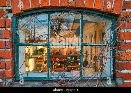 Old leaded painted wood window in an arched red brick wall Stock Photo