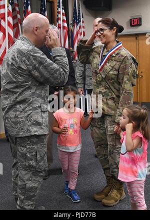 Tech. Sgt. April Castro-Tover, 66th Air Base Group chaplain assistant, salutes Col. Roman Hund, installation commander, during the Hanscom Heroes Homecoming event at the base conference center July 19, as her daughters, Anani, right, and Azlyn, look on. During the ceremony, the base welcomed home approximately 30 of the nearly 50 service members who have returned from deployment in the past year. Stock Photo