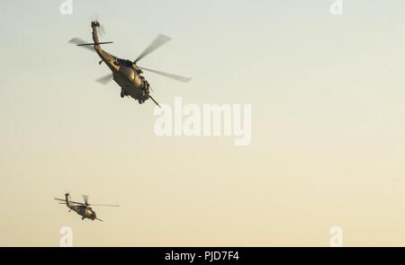 HH-60 Pave Hawks assigned to the 46th Expeditionary Rescue Squadron arrive at the site of a simulated aircraft crash site to provide personnel recovery operations and support for Battlefield Airmen assigned to the 52nd Expeditionary Rescue Squadron on the ground assisting exercise players in an undisclosed location, Iraq, July 15, 2018. The primary mission of the HH-60G Pave Hawk helicopter is to conduct day or night personnel recovery operations into hostile environments to recover isolated personnel during war. Stock Photo