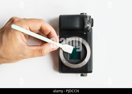 Close-up of camera matrix cleaning, technician pov. Photographer cleaning photocamera light sensor. Professional photographing equipment care, technol Stock Photo
