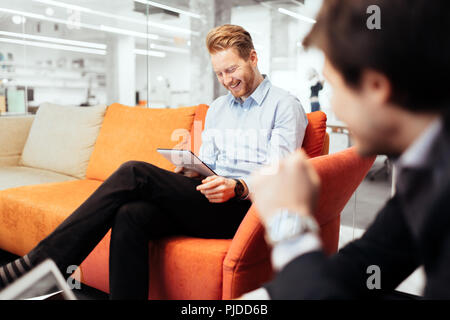 Businesspeople working while looking at devices Stock Photo