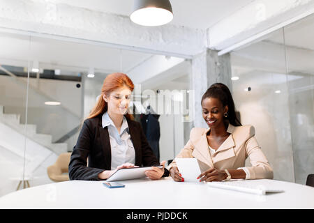 Two attractive businesswomen using technology Stock Photo
