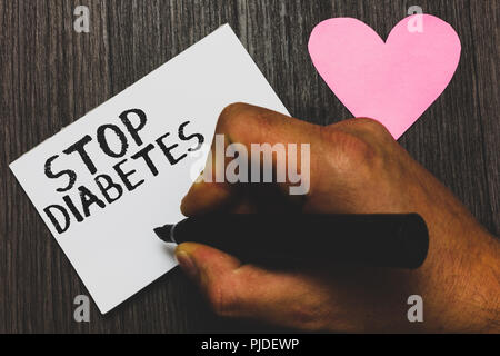 Handwriting text writing Stop Diabetes. Concept meaning Blood Sugar Level is higher than normal Inject Insulin Man hand holding marker white paper rom Stock Photo